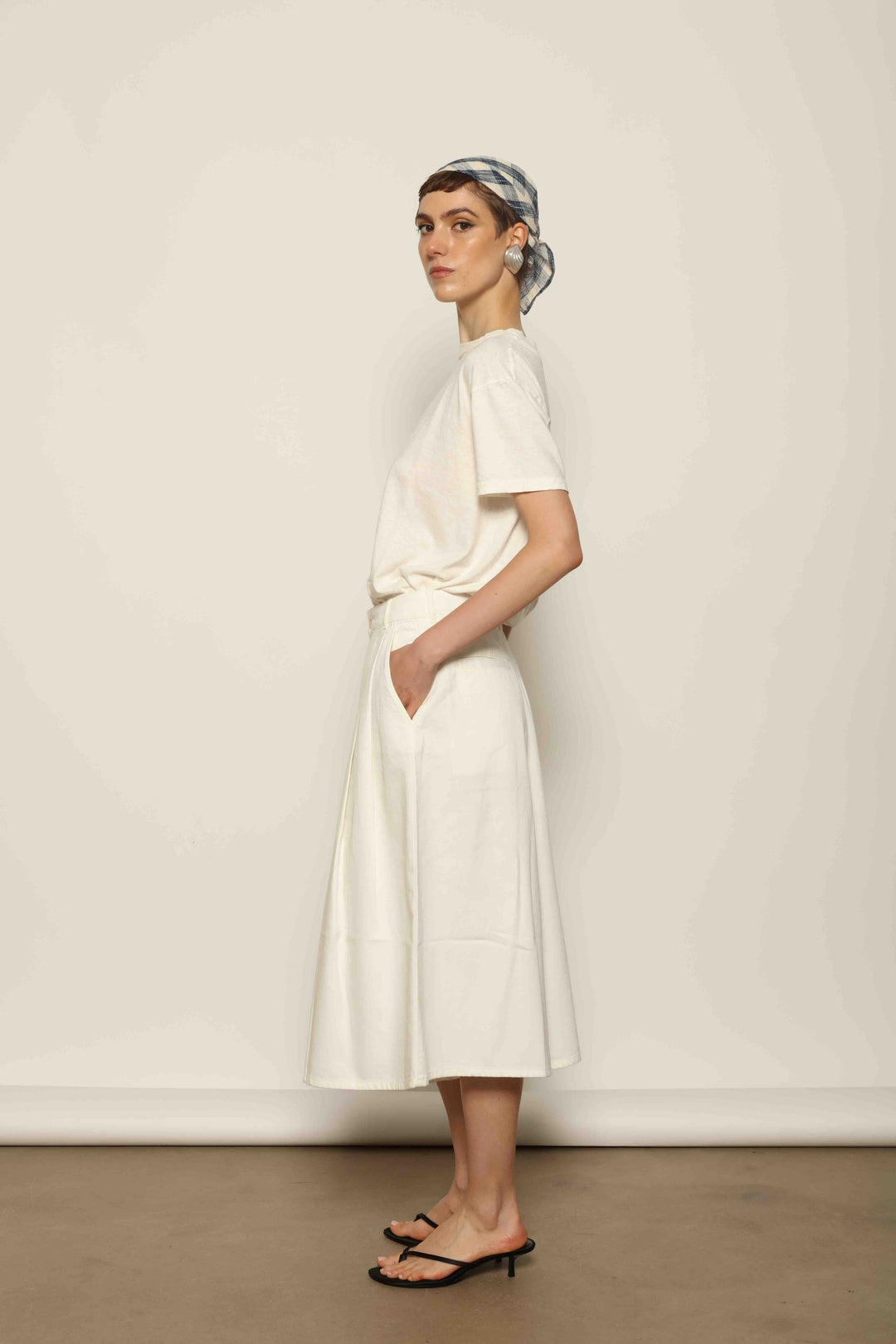 Model wearing the La Jupe Culotte in Blanc Cassè by Happy Haus from the House of Nomad Stories collection, featuring premium Japanese denim, a high-waisted fit, wide-leg silhouette, and elegant ankle-length design.