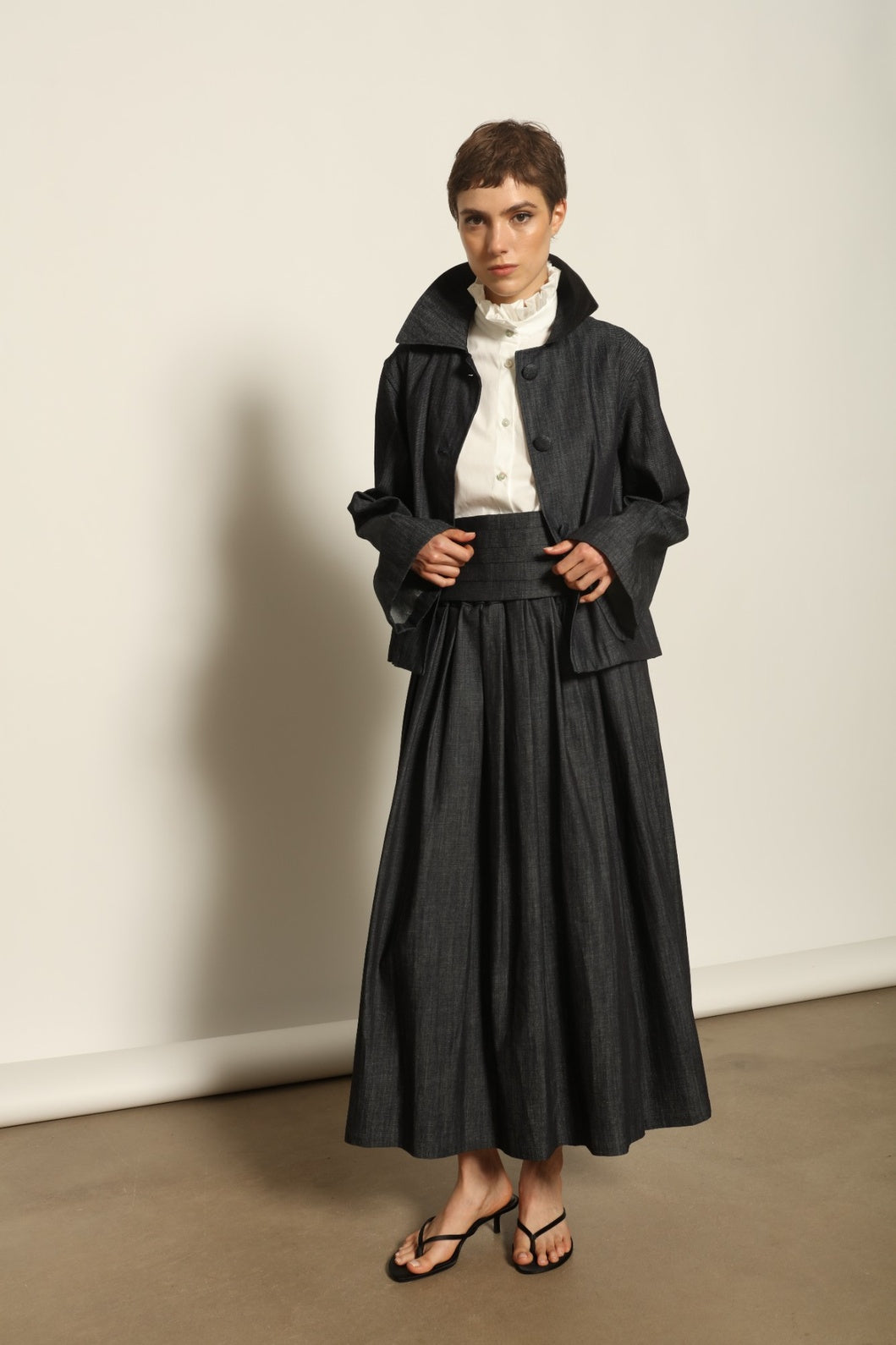 Model wearing the Seoul Ink Denim Skirt by House of Nomad Stories, featuring deep indigo denim, a structured silhouette, and refined tailoring for a timeless and elegant look.
