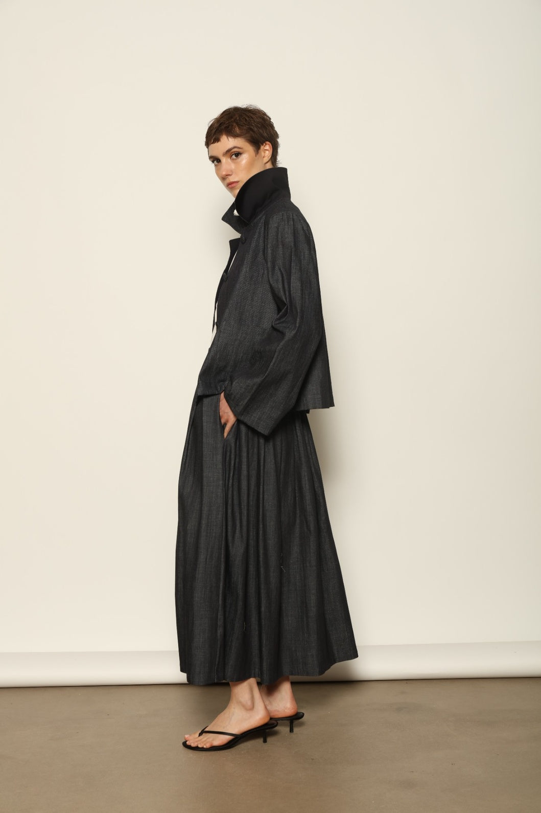 Model wearing the Seoul Ink Denim Skirt by House of Nomad Stories, featuring deep indigo denim, a structured silhouette, and refined tailoring for a timeless and elegant look.