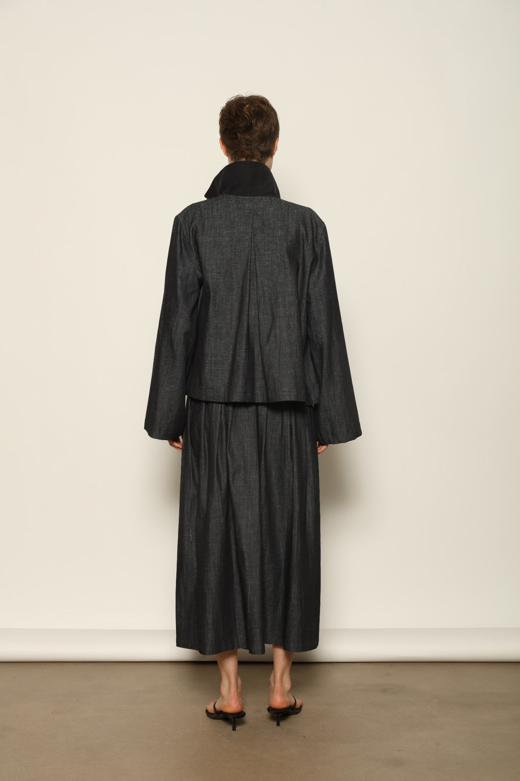 Model wearing the Seoul Ink Denim Skirt by House of Nomad Stories, featuring deep indigo denim, a structured silhouette, and refined tailoring for a timeless and elegant look.