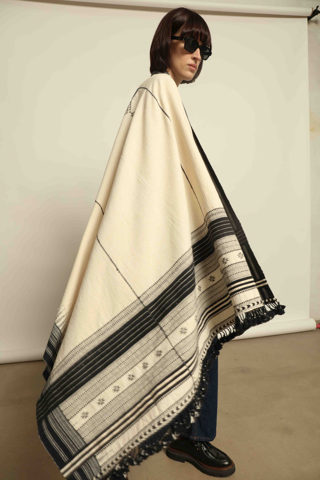 Handwoven Kala cotton throw Ananta by House of Nomad Stories, crafted with handspun yarn and embroidered panels by master weaver Shamji Vankar Vishram Valji in Bhujodi, India.