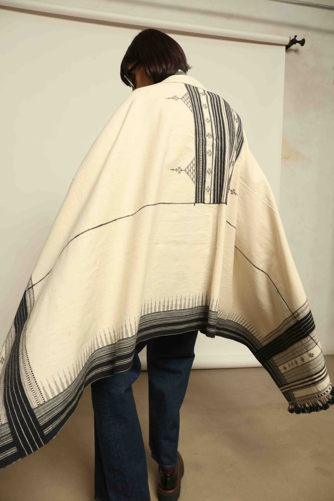 Handwoven Kala cotton throw Ananta by House of Nomad Stories, crafted with handspun yarn and embroidered panels by master weaver Shamji Vankar Vishram Valji in Bhujodi, India.