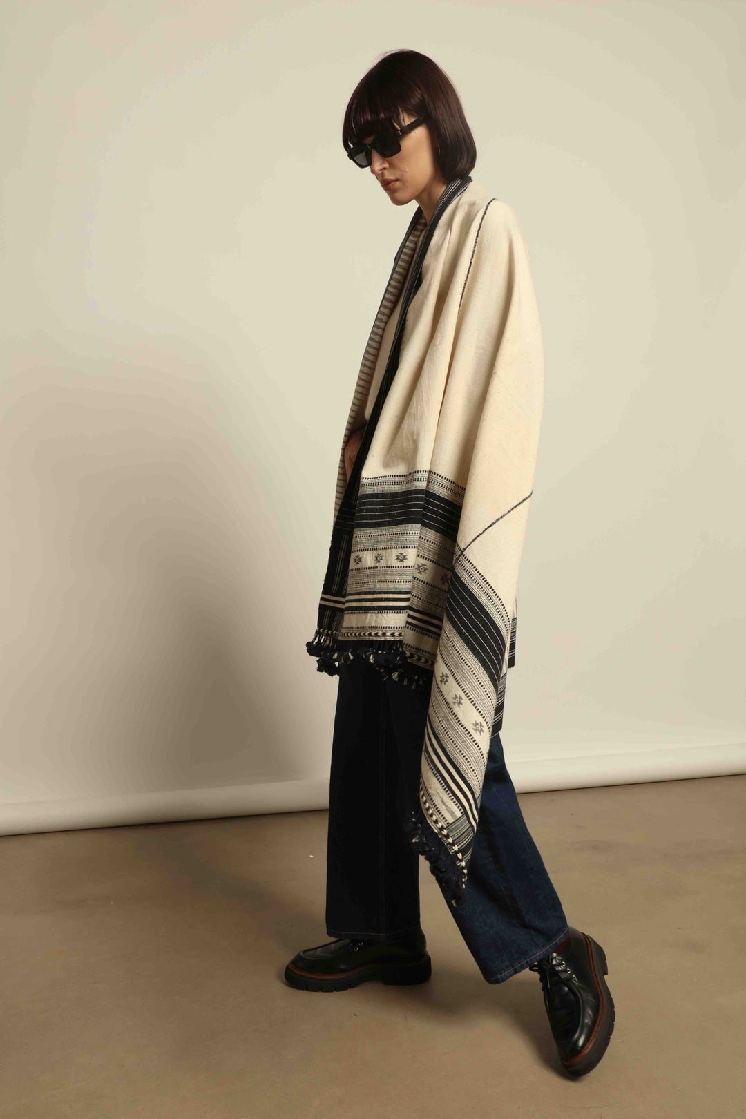 Handwoven Kala cotton throw Ananta by House of Nomad Stories, crafted with handspun yarn and embroidered panels by master weaver Shamji Vankar Vishram Valji in Bhujodi, India.