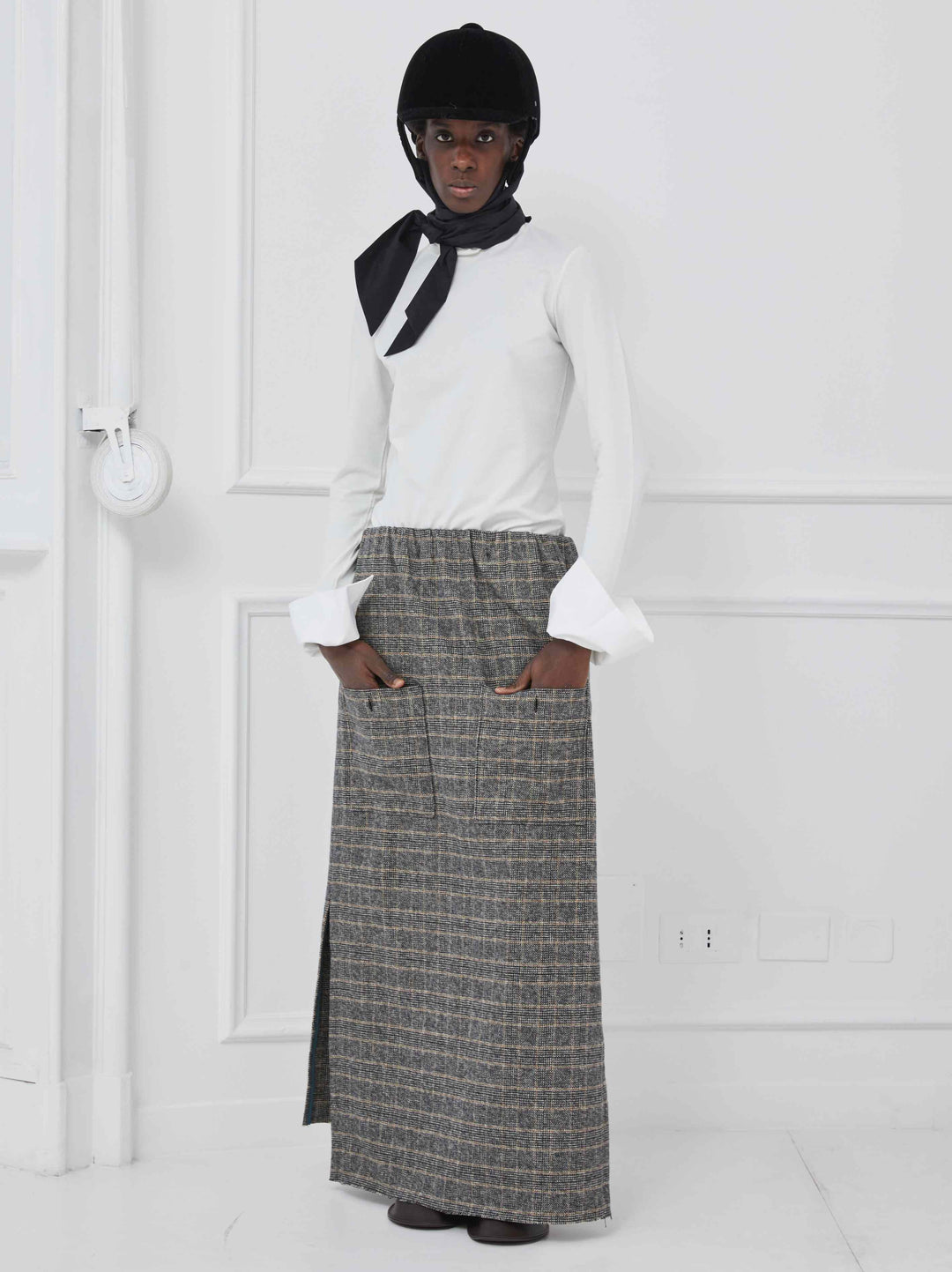 Model is wearing the Illa Cotton Check Skirt by Maison Jejia, part of the House of Woven Stories selection, featuring a classic check pattern, soft cotton fabric, and a flattering silhouette.