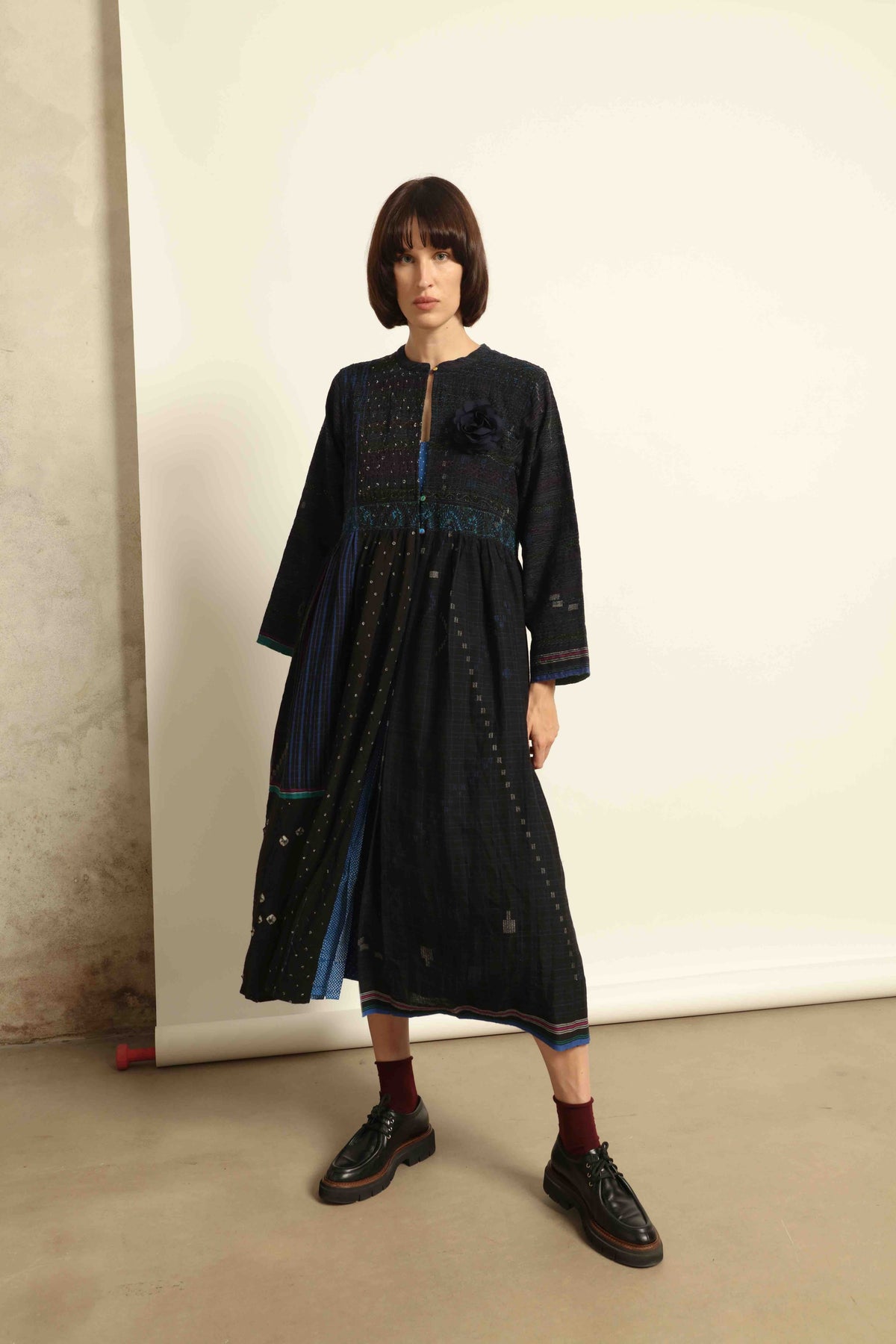 Model is wearing the Folklore 20 dress by Injiri, handmade from silk and wool using traditional Indian handloom techniques, featuring a round neckline, long sleeves, side pockets, and a flattering cut below the bust, curated by House of Nomad Stories.