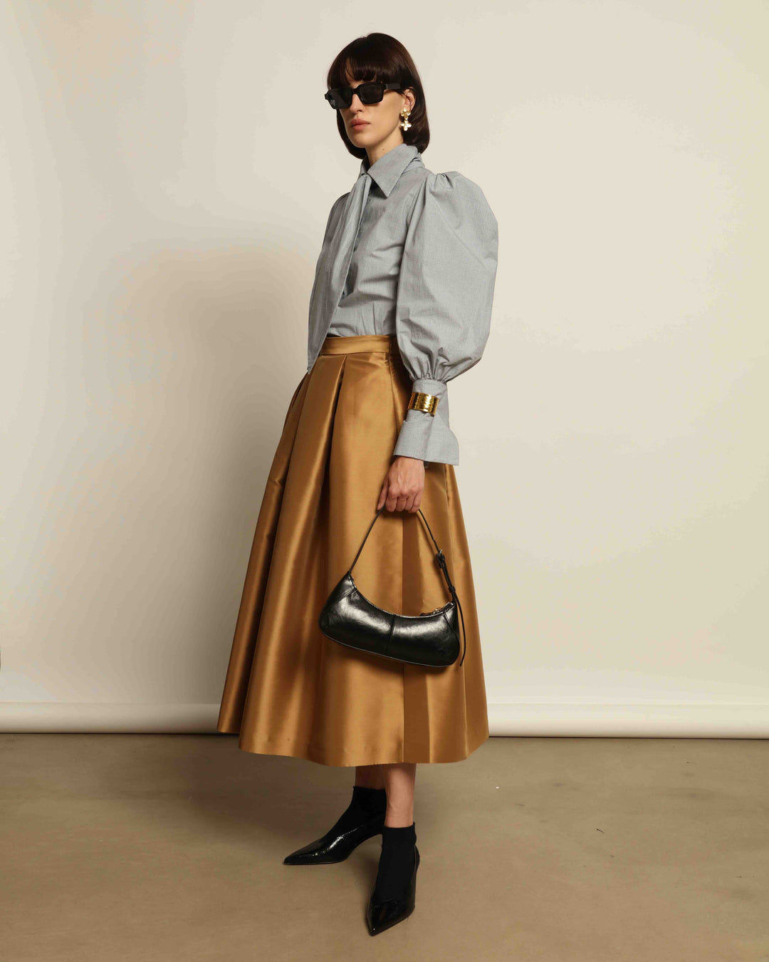 Model is wearing the Karin Micro Check Vichy Cotton Shirt by House of Woven Stories, featuring puffed sleeves, a detachable tie, and a timeless checked design, handmade in Italy from 100% organic cotton.