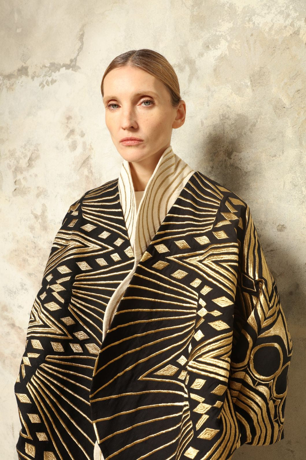 Model is wearing the Sunhera Reversible Jacket by Ka-Sha, a handcrafted cotton piece with rich gold stitching, offering two looks — black and gold or beige and gold — crafted over 65 hours and curated in the House of Woven Stories selection.
