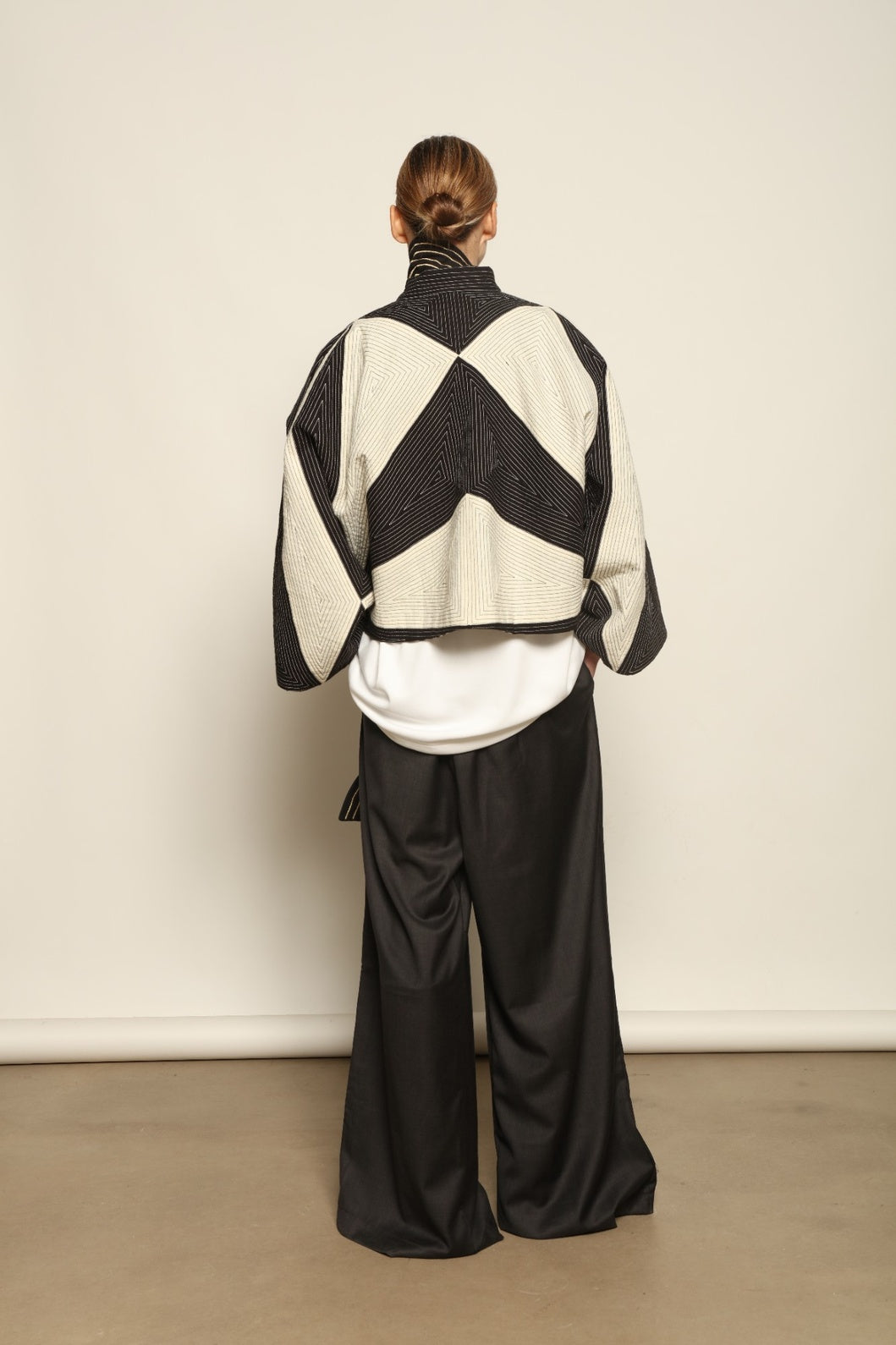 Model is wearing the Tri Crop Moma in black by Ka-Sha, a sculptural heavyweight organic cotton cropped top with geometric panels, curated in the House of Woven Stories selection.
