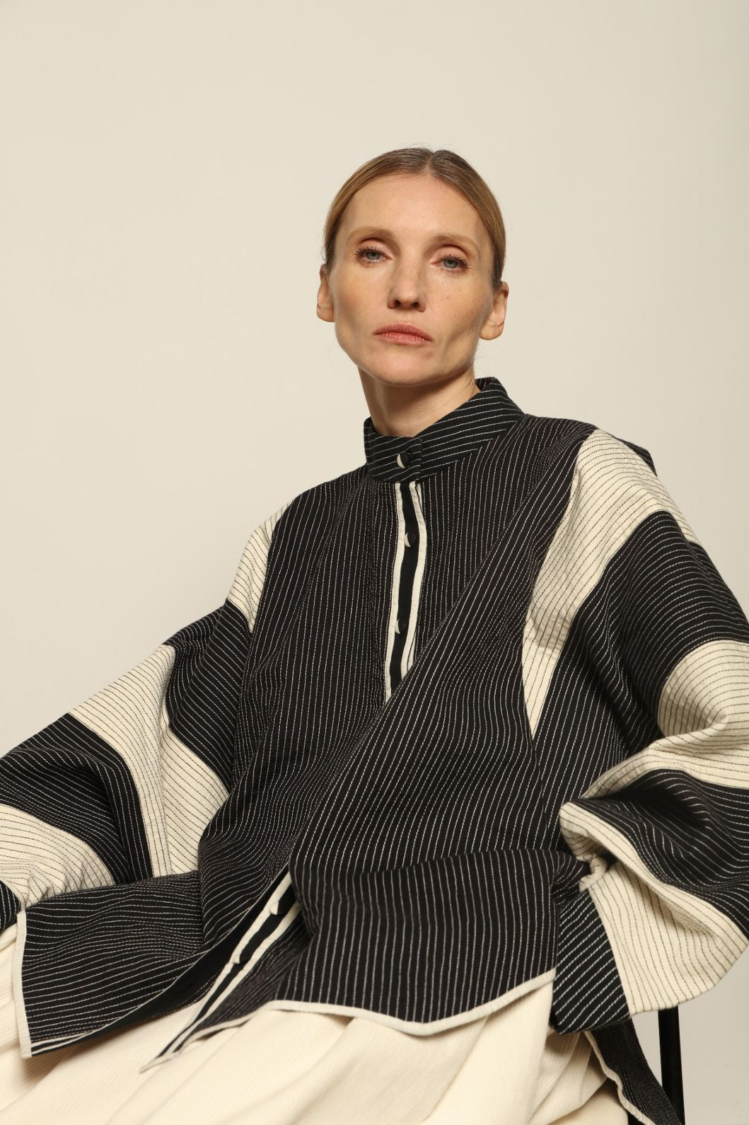 Model is wearing the Tri Bat Reversible Jacket by Ka-Sha, an artisanal reversible cotton jacket with bold black-and-white panels and wide sculptural sleeves, curated in the House of Woven Stories selection.