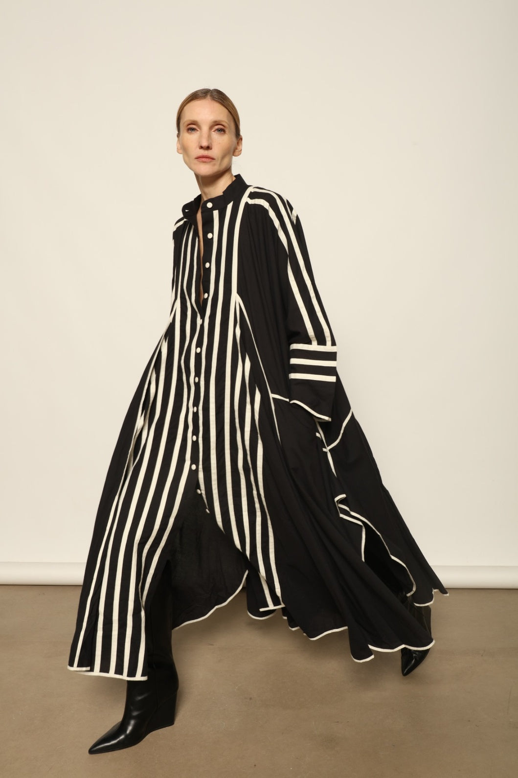 Model is wearing the Vibhor Tunic by Ka-Sha, a handcrafted black cotton tunic with off-white stripes, flowing sleeves and button-down front, curated in the House of Woven Stories selection.