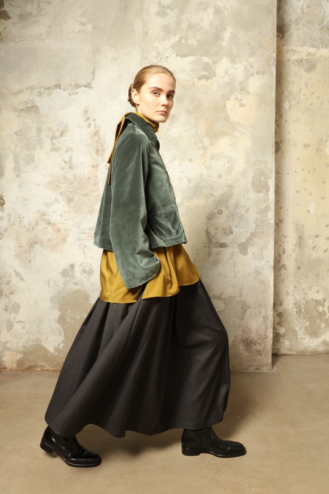 Model wearing Katharina Jacket in Velvet Green Cotton by House of Woven Stories, part of the curated selection, handcrafted in Italy from fine cotton velvet with hand-dyed shibori lining, expressing timeless elegance and artisanal craftsmanship.