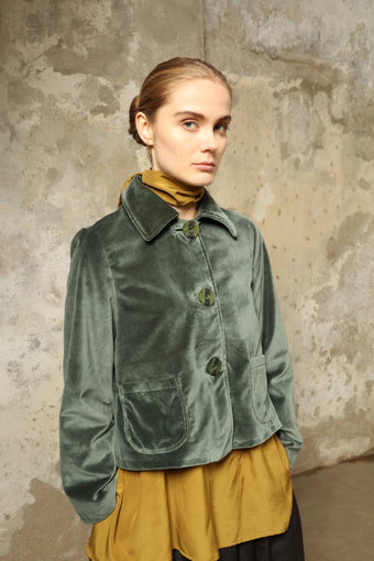 Model wearing Katharina Jacket in Velvet Green Cotton by House of Woven Stories, part of the curated selection, handcrafted in Italy from fine cotton velvet with hand-dyed shibori lining, expressing timeless elegance and artisanal craftsmanship.