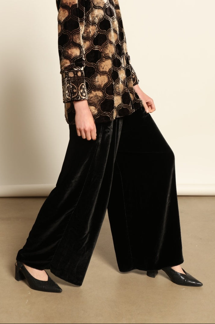 Model is wearing the Kati Black Velvet Trousers by Obidi, crafted from luxurious velvet with a tailored silhouette, combining timeless craftsmanship with modern versatile style.