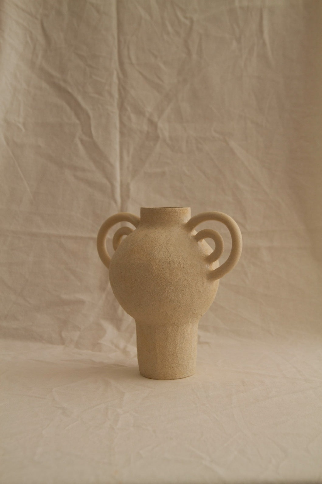 L’Enfant Lune aux Doubles Anses by Clandestine Céramique, handbuilt in sandy clay with double curving handles and soft glaze, part of the House of Nomad Stories selection.