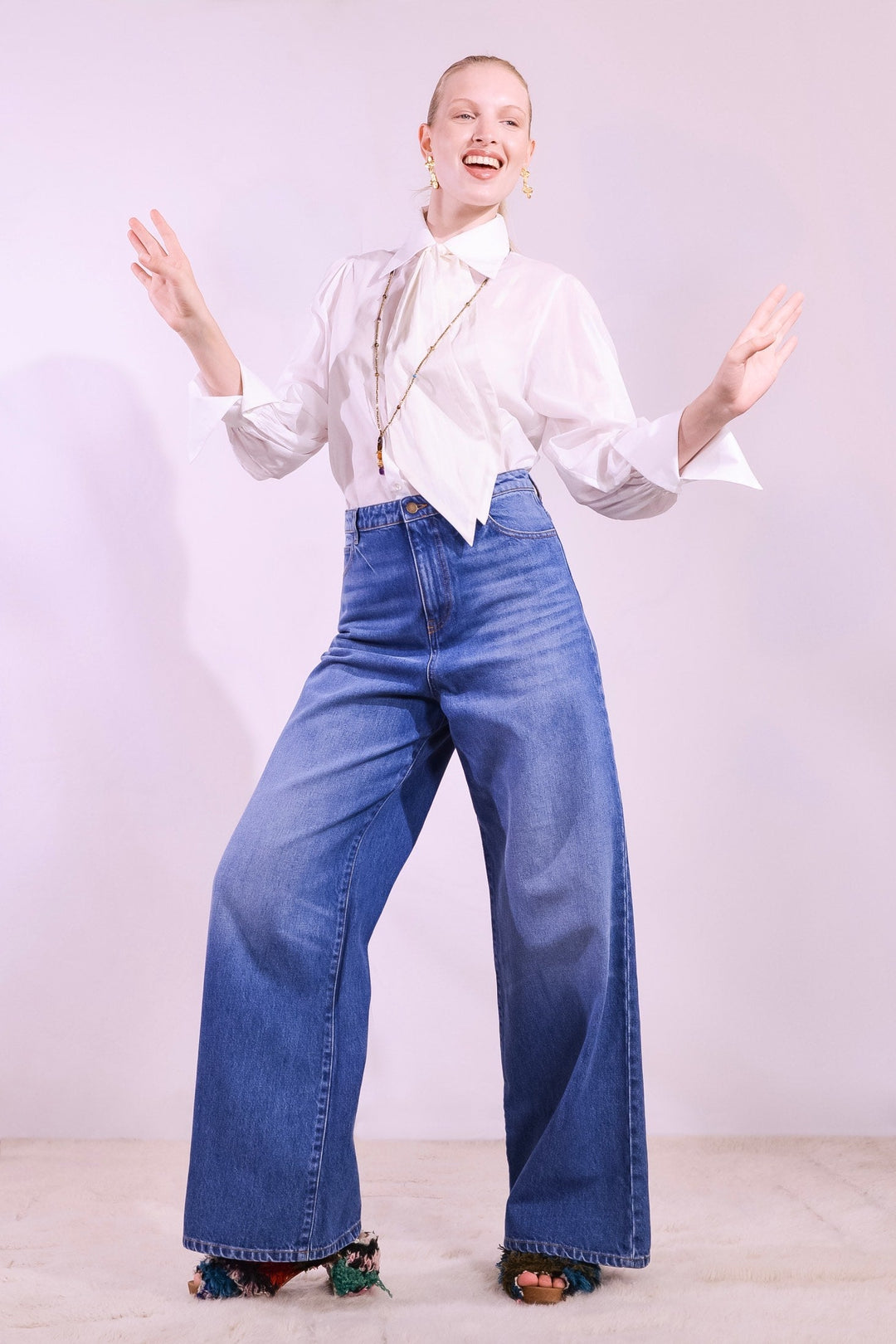 Model is wearing the Le Pantalon Baggy in Bleu d’Été Vintage by Happy Haus - relaxed boyfriend-style recycled denim jeans with wooden button, flower-shaped back pockets, and tobacco-colored topstitching.