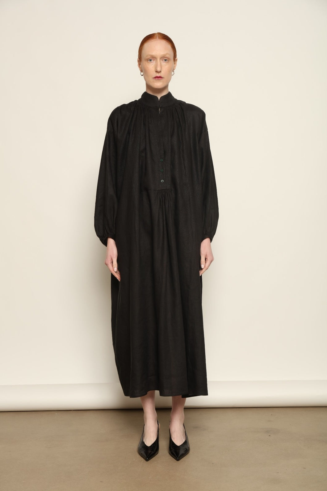 Model is wearing the Les Vacances d’Irina Black Sea Linen Dress, handcrafted from 100% linen with billowing sleeves and a gathered neckline, from the House of Nomad Stories selection.