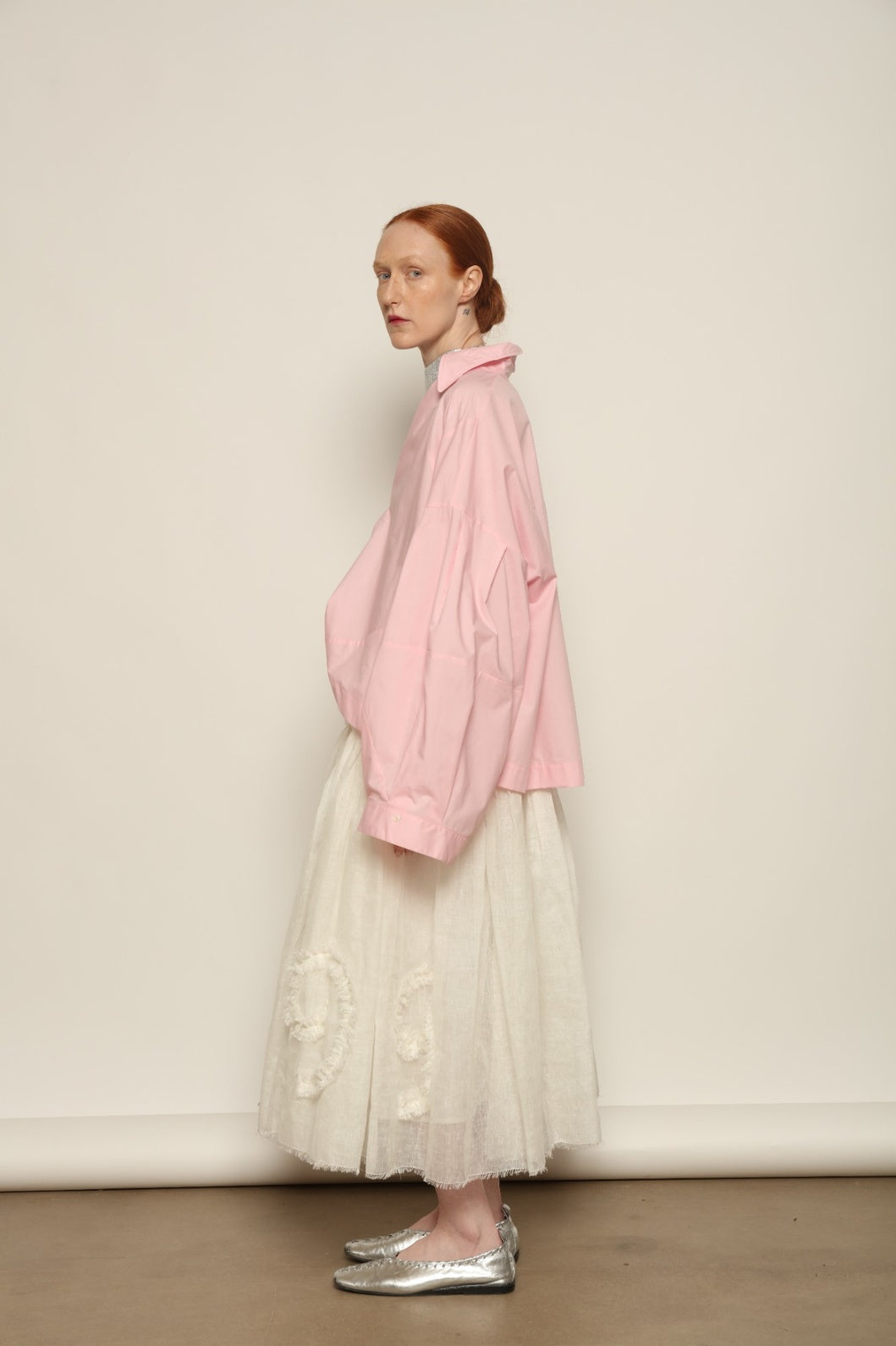 Model is wearing the Les Vacances d’Irina Shell White Skirt, handcrafted from linen with voluminous silhouette and hand-applied ruffles, from the House of Nomad Stories selection.