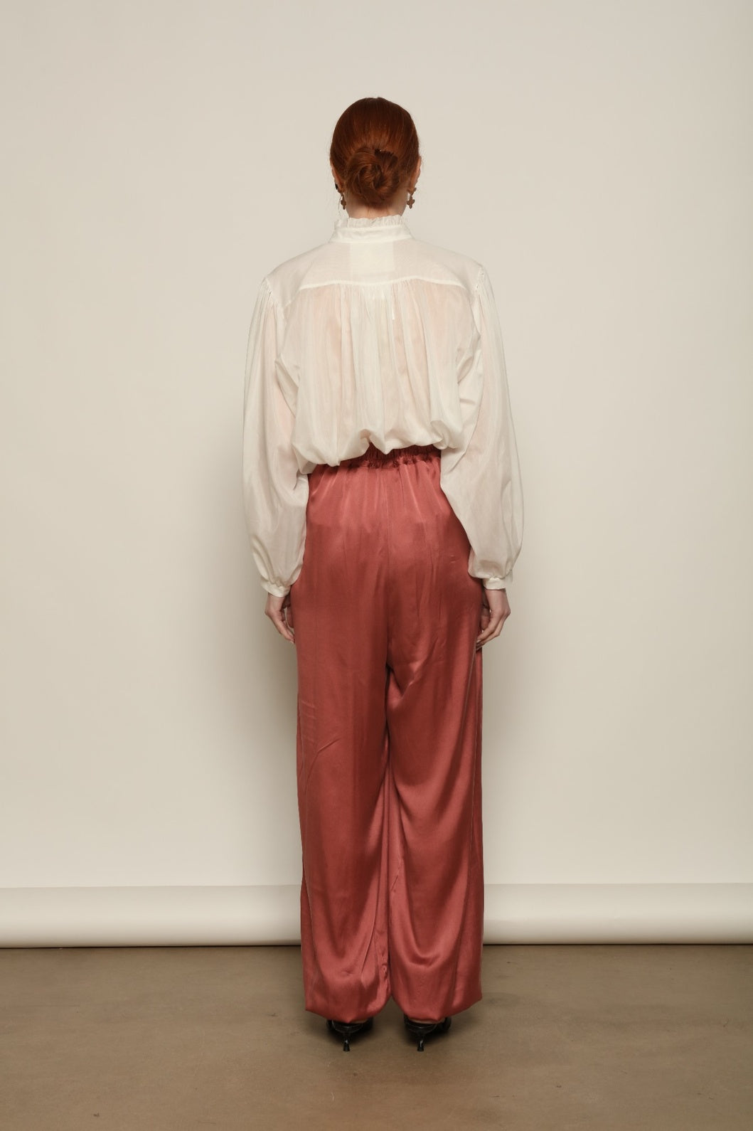 Model is wearing the Les Vacances d’Irina Victorian White Blouse with ruffled collar, front frills and voluminous sleeves, handcrafted in Bucharest, from the House of Nomad Stories selection.