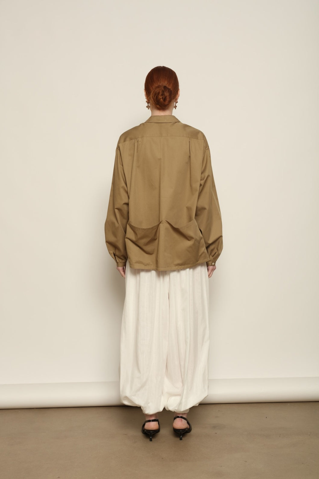 Model is wearing the Les Vacances d’Irina Vulcano White Pants, handcrafted from 100% cotton with a balloon silhouette and gathered ankles, from the House of Nomad Stories selection.