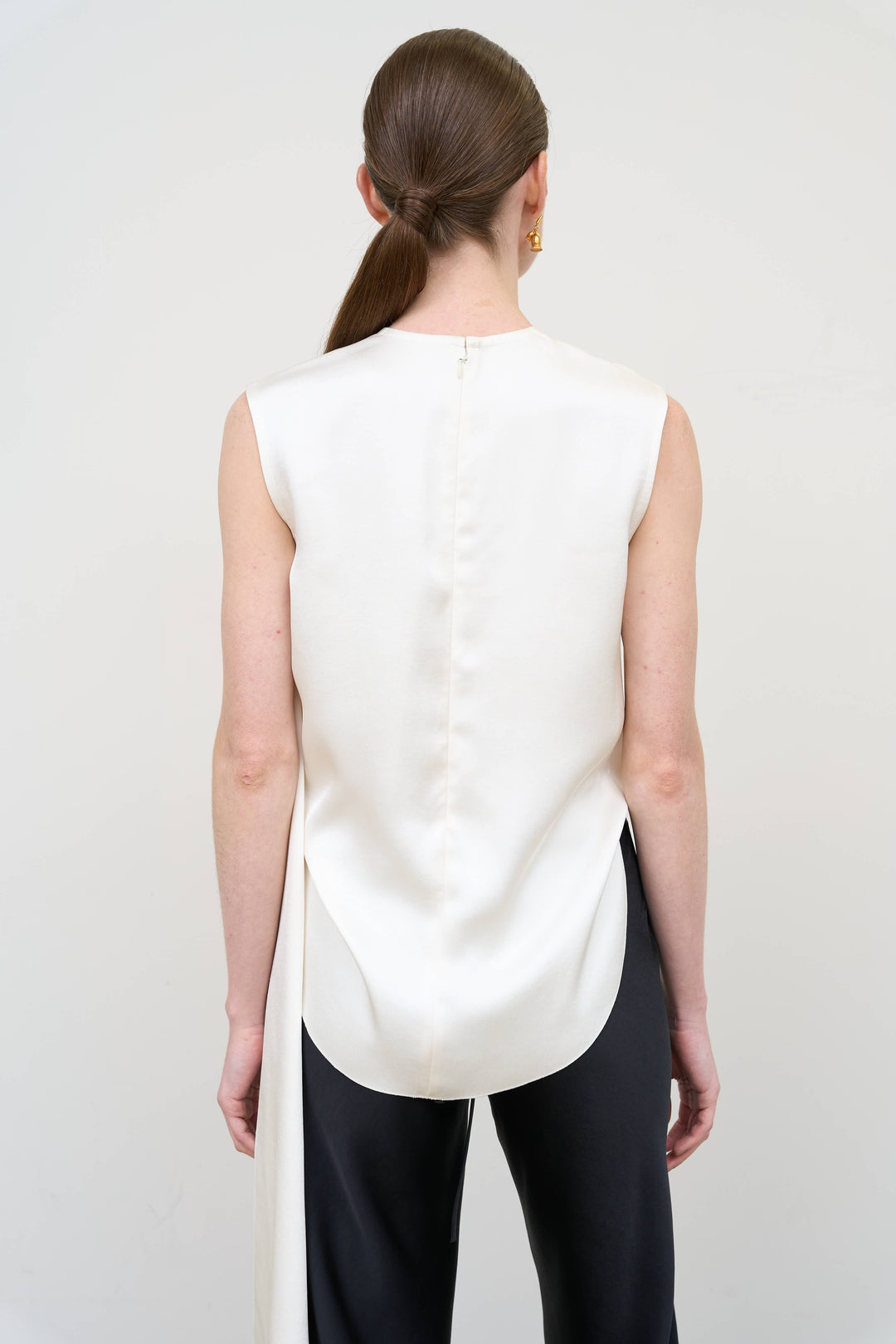 Model is wearing Litkovska asymmetric twist white top showcasing sculptural draping and contemporary designer womenswear at House of Nomad Stories