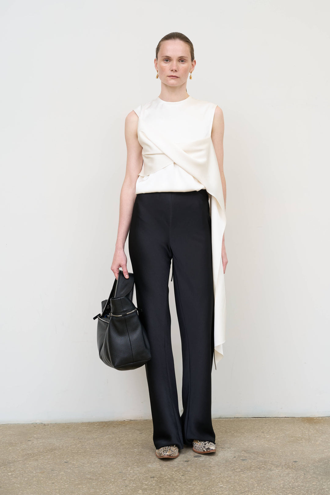 Model is wearing Litkovska asymmetric twist white top showcasing sculptural draping and contemporary designer womenswear at House of Nomad Stories
