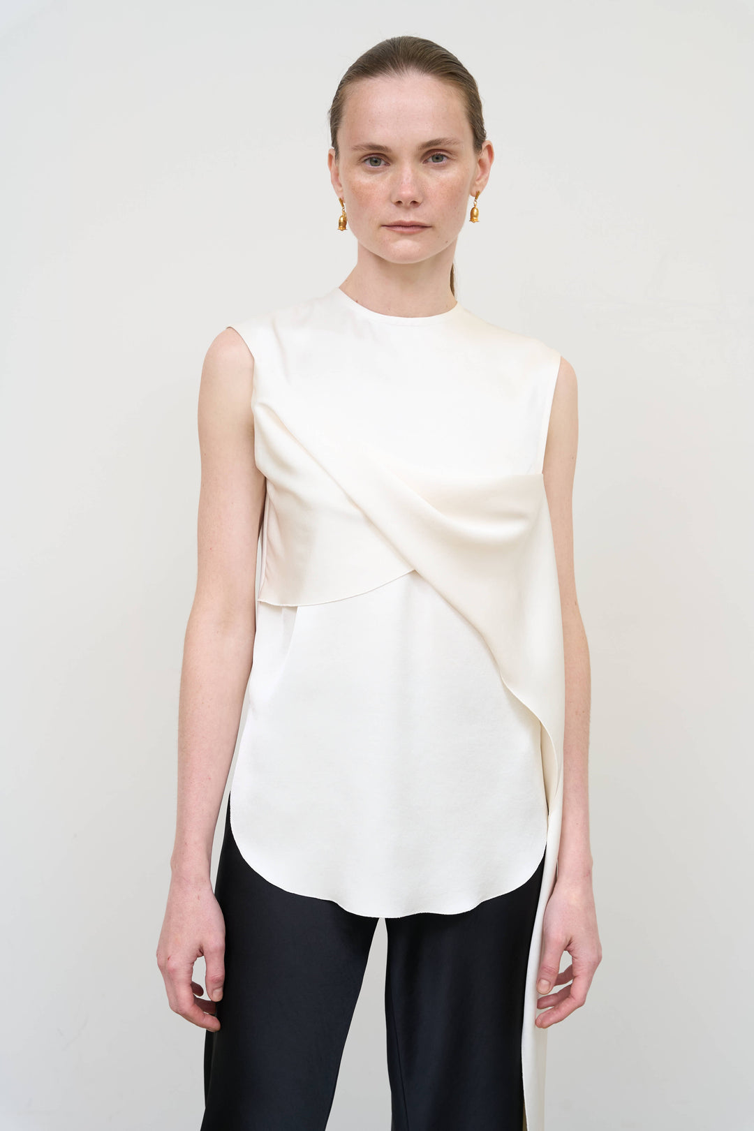 Model is wearing Litkovska asymmetric twist white top showcasing sculptural draping and contemporary designer womenswear at House of Nomad Stories