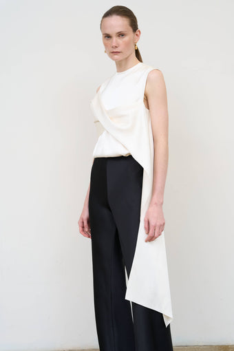 Model is wearing Litkovska asymmetric twist white top showcasing sculptural draping and contemporary designer womenswear at House of Nomad Stories