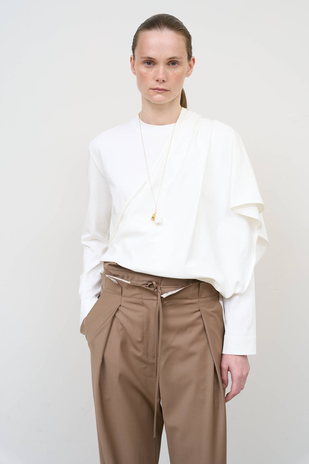Model is wearing Litkovska asymmetric white cotton longsleeve showcasing elongated silhouette and contemporary designer womenswear at House of Nomad Stories