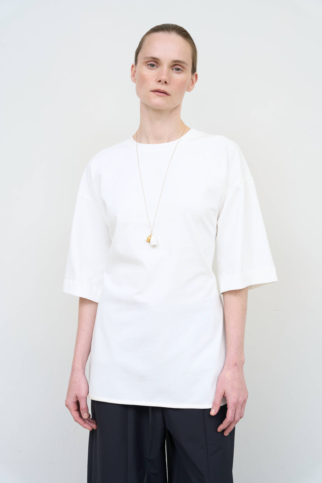 Model is wearing Litkovska corset white T-shirt showcasing tailored waist detail and contemporary designer womenswear at House of Nomad Stories