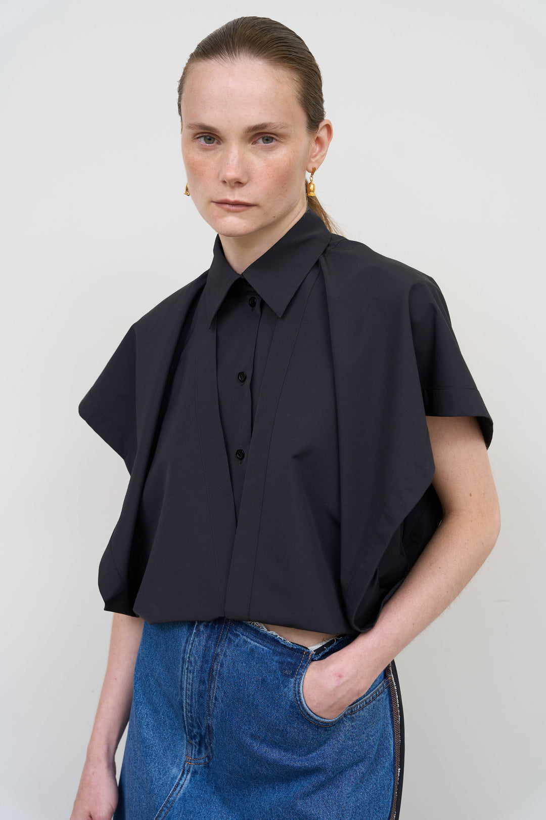 Model is wearing Litkovska black deconstructed wool blend shirt featuring layered tailoring and architectural womenswear design at House of Nomad Stories