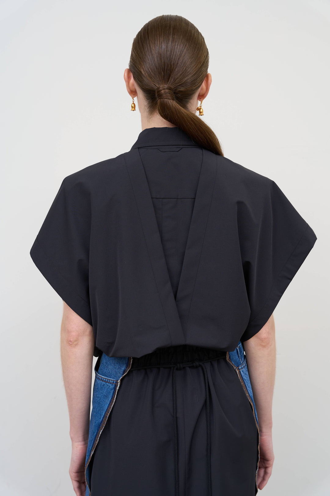 Model is wearing Litkovska black deconstructed wool blend shirt featuring layered tailoring and architectural womenswear design at House of Nomad Stories