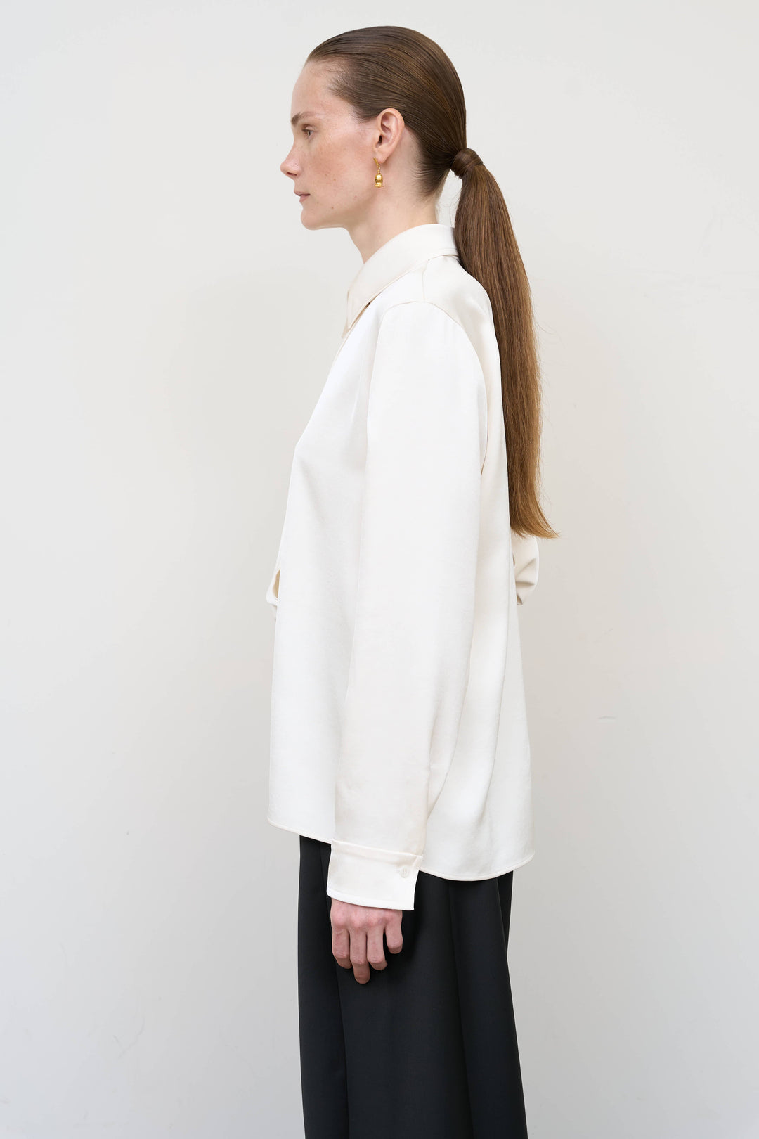 Model is wearing Litkovska ivory blouse with integrated scarf detail, showcasing layered tailoring and fluid contemporary womenswear design from House of Nomad Stories
