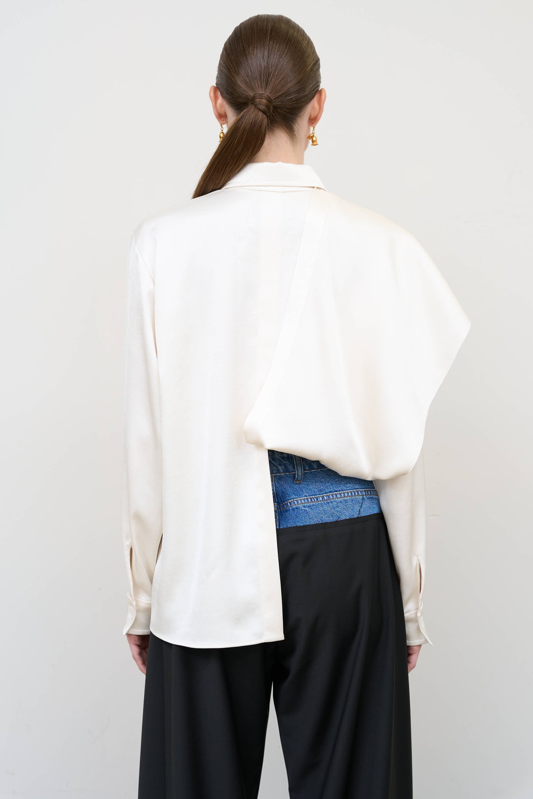 Model is wearing Litkovska ivory blouse with integrated scarf detail, showcasing layered tailoring and fluid contemporary womenswear design from House of Nomad Stories