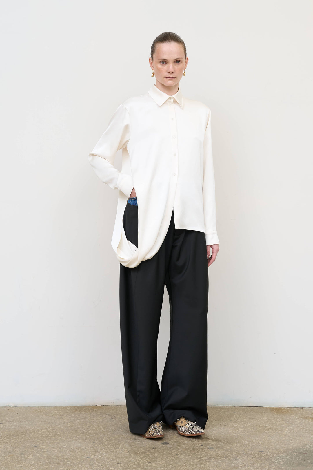 Model is wearing Litkovska ivory blouse with integrated scarf detail, showcasing layered tailoring and fluid contemporary womenswear design from House of Nomad Stories