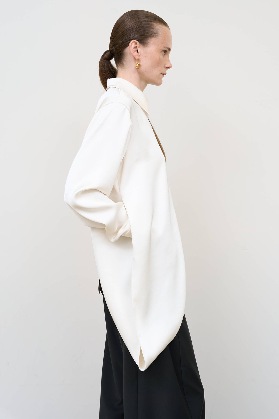 Model is wearing Litkovska ivory blouse with integrated scarf detail, showcasing layered tailoring and fluid contemporary womenswear design from House of Nomad Stories