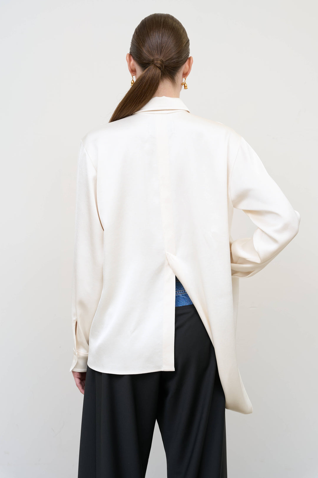 Model is wearing Litkovska ivory blouse with integrated scarf detail, showcasing layered tailoring and fluid contemporary womenswear design from House of Nomad Stories