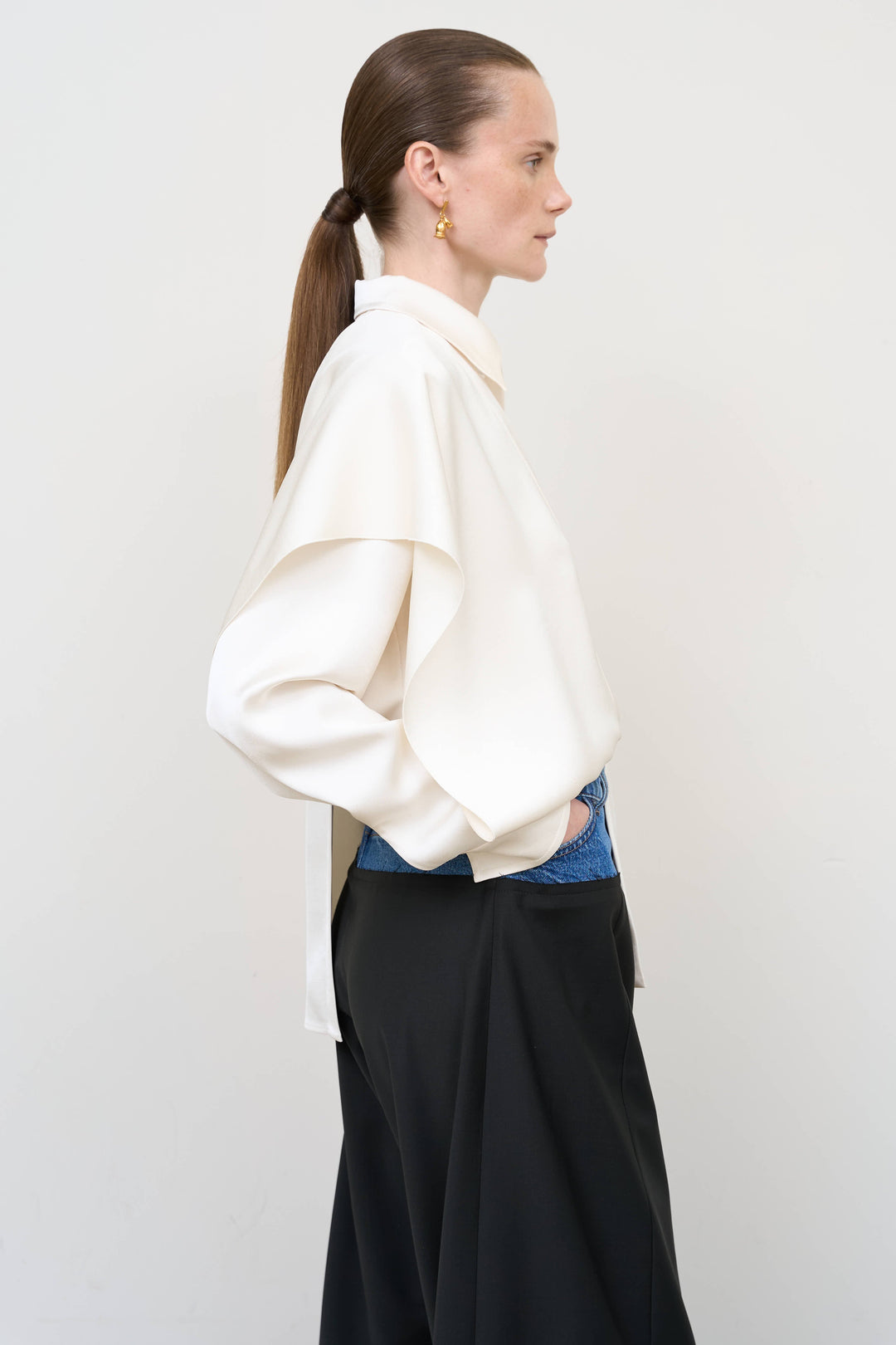 Model is wearing Litkovska ivory blouse with integrated scarf detail, showcasing layered tailoring and fluid contemporary womenswear design from House of Nomad Stories