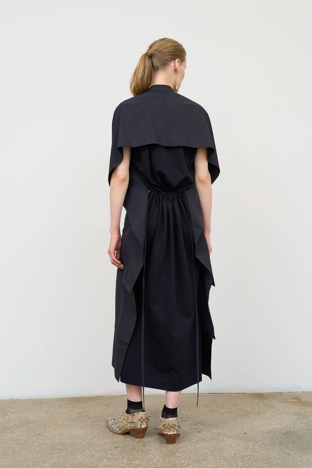 Model is wearing Litkovska midi dress with capelet detail, showcasing layered tailoring and contemporary Ukrainian womenswear at House of Nomad Stories
