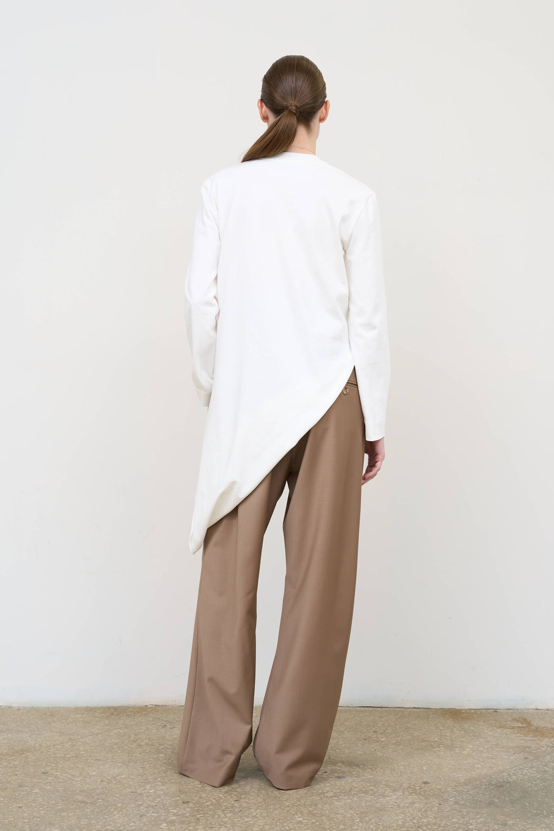 Model is wearing Litkovska pleated drawstring pants showcasing relaxed tailoring and contemporary designer womenswear at House of Nomad Stories