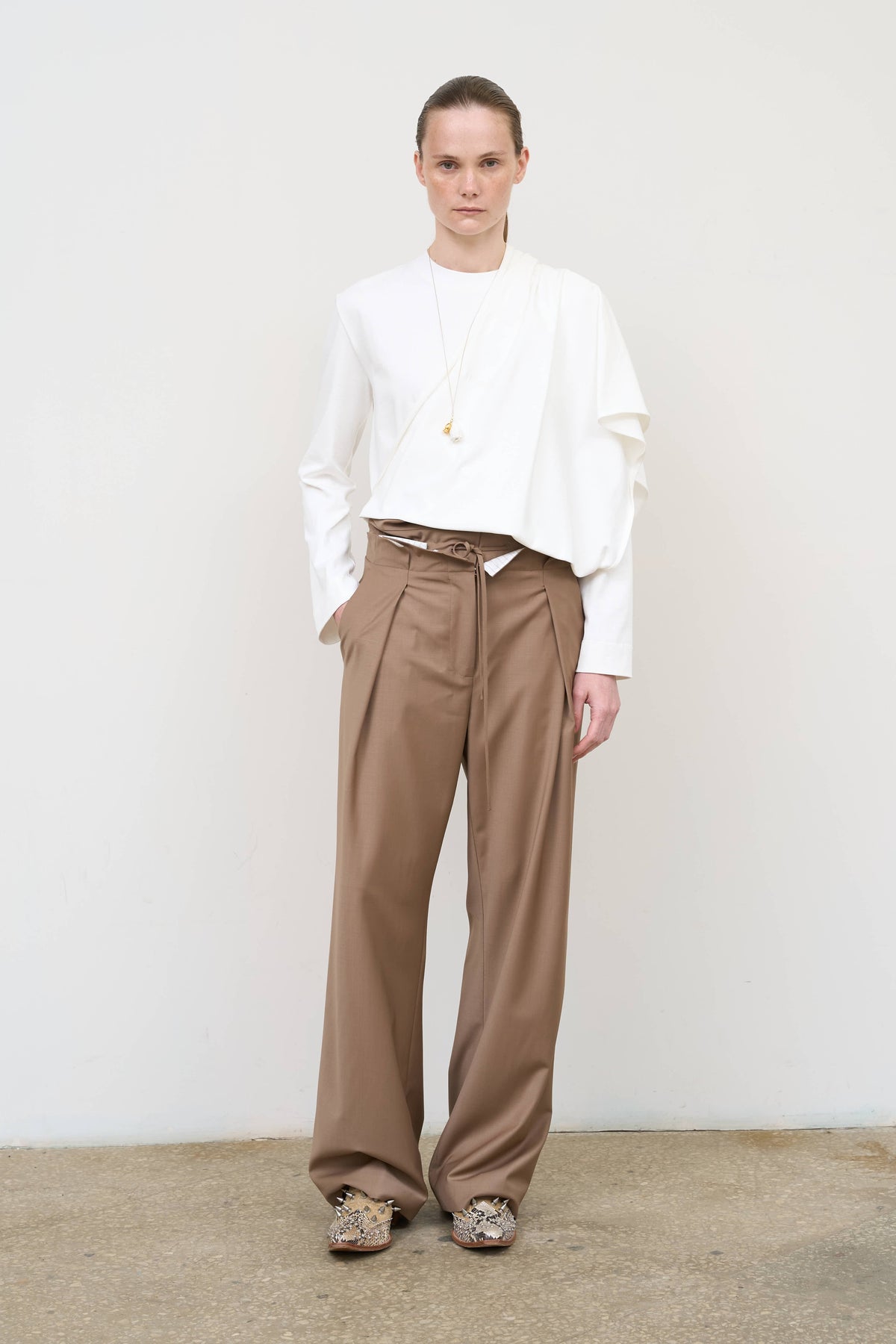 Model is wearing Litkovska pleated drawstring pants showcasing relaxed tailoring and contemporary designer womenswear at House of Nomad Stories