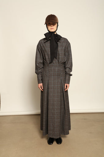 Model is wearing the Londra Brown Checked Skirt by House of Nomad Stories, ankle-length with fine pleats and brown checked pattern, combining timeless tailoring with contemporary elegance and quality craftsmanship.