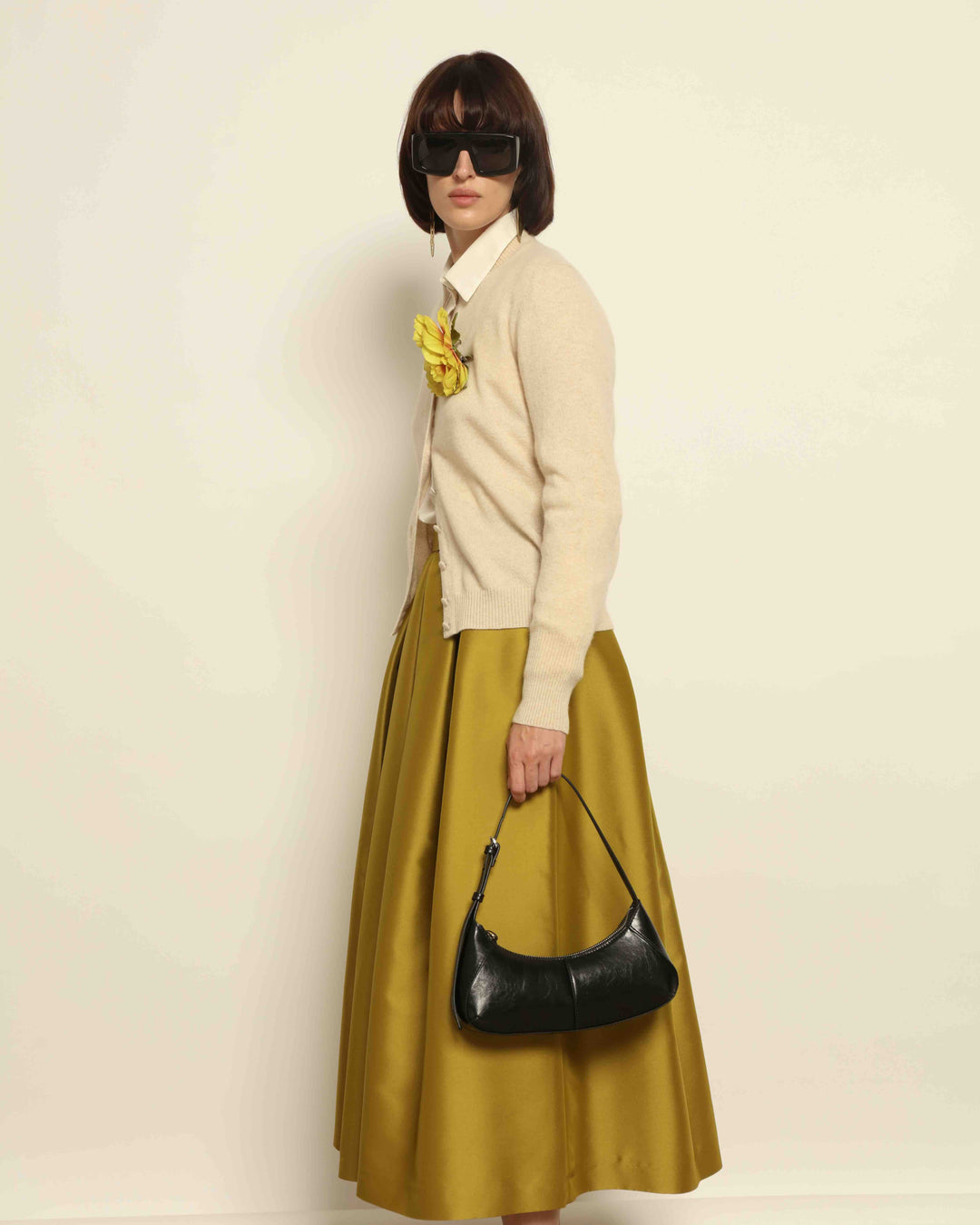 Model is wearing Duchesse Oliva Skirt by Lunatica Milano available at House of Nomad Stories. Pleated maxi skirt in a luxurious soft-blend fabric. Elegant, feminine, and handmade in Italy.
