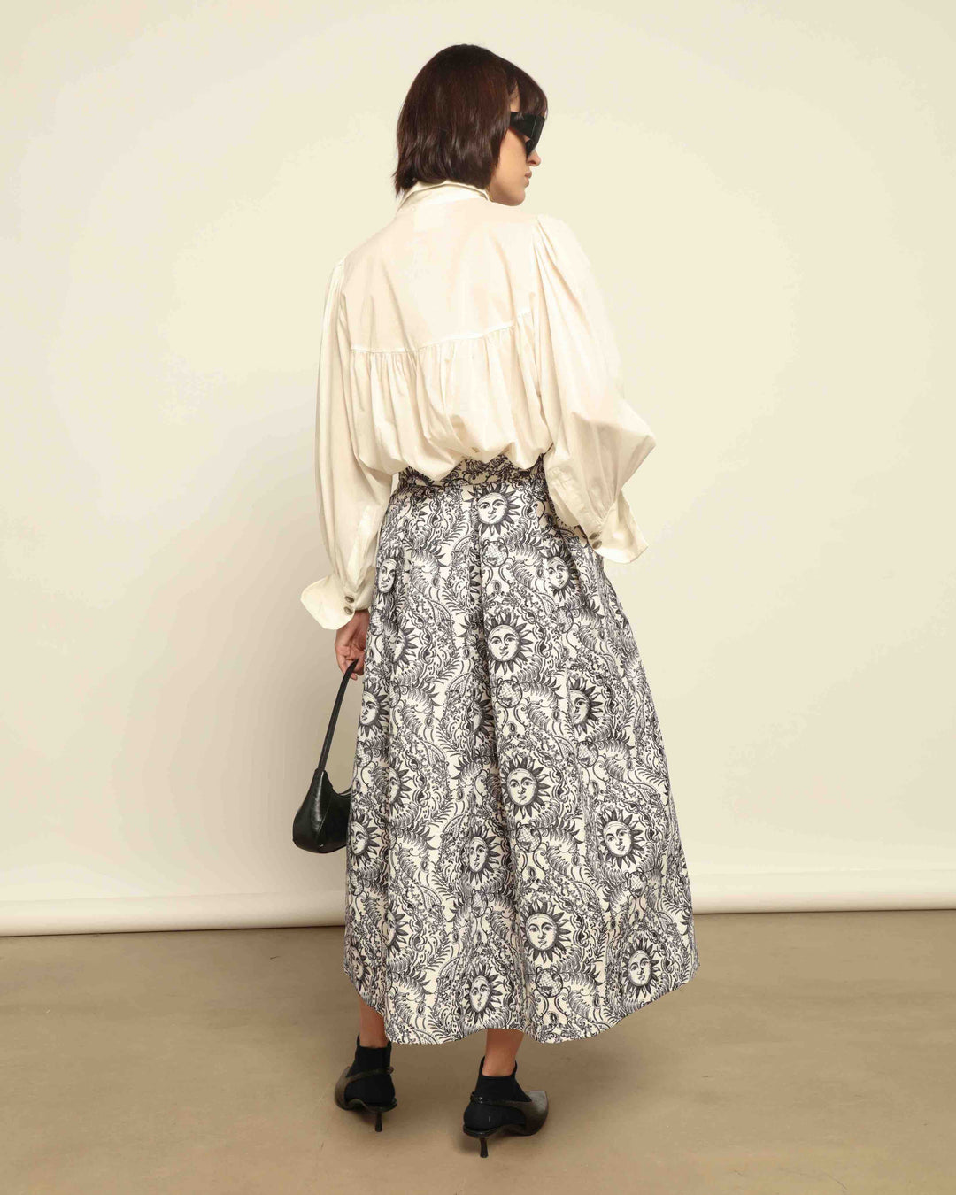 Model is wearing Sun Black and White Skirt by Lunatica Milano. Romantic floral skirt in classic black and white. Elegant, feminine, and handcrafted in Italy. Part of House of Nomad Stories selection.