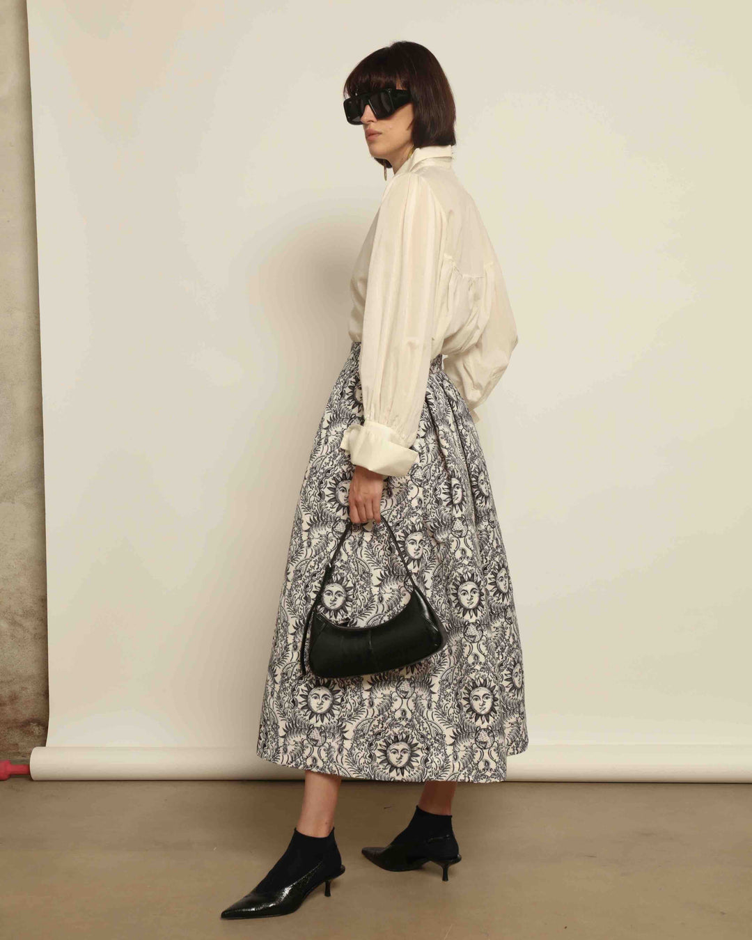 Model is wearing Sun Black and White Skirt by Lunatica Milano. Romantic floral skirt in classic black and white. Elegant, feminine, and handcrafted in Italy. Part of House of Woven Stories selection.
