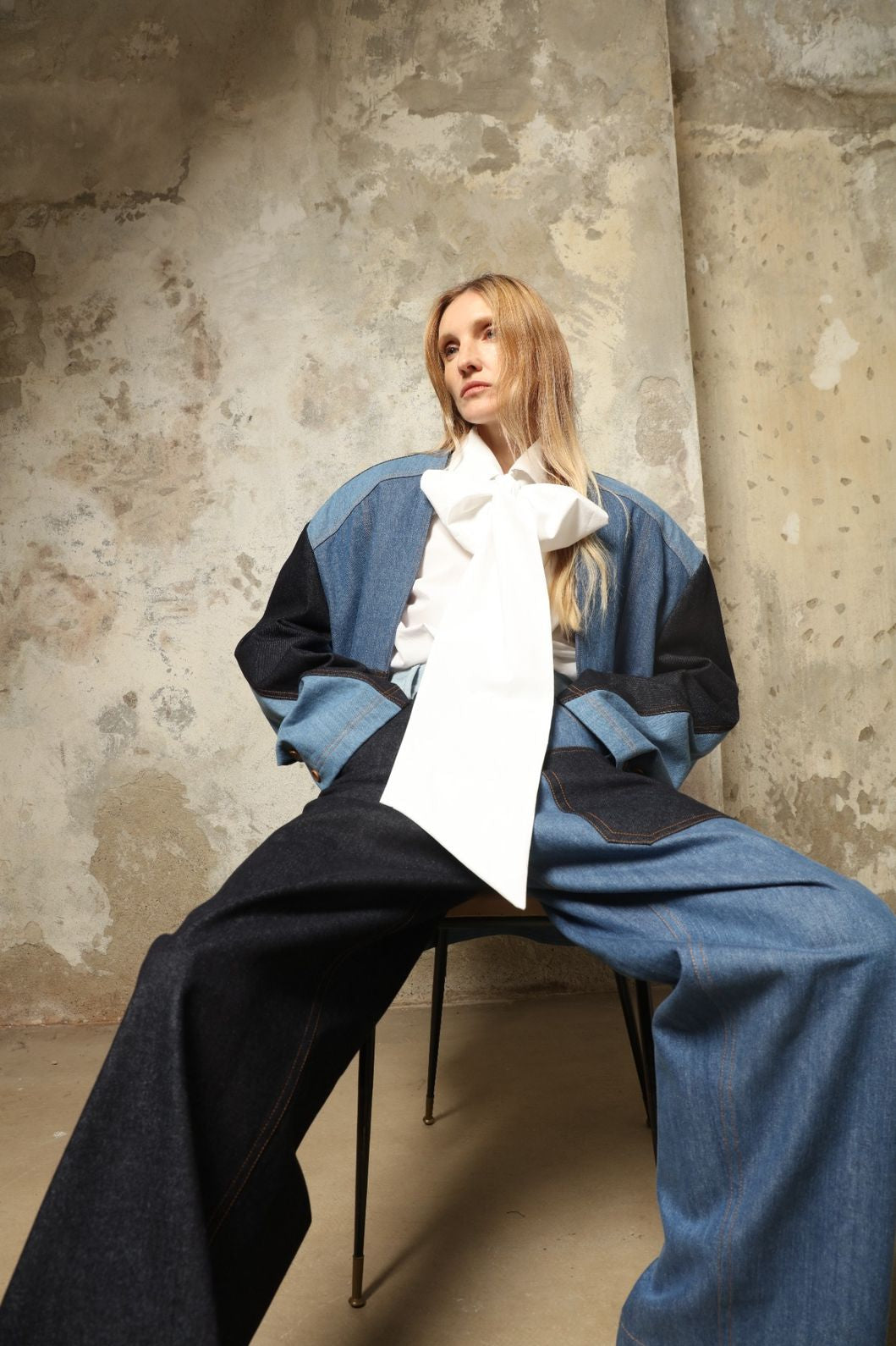 Model is wearing the Carla Denim Patchwork Pant by Maison Jejia, tailored denim trousers crafted from mixed-wash patches with a relaxed structured silhouette and fine stitching, curated in the House of Nomad Stories selection