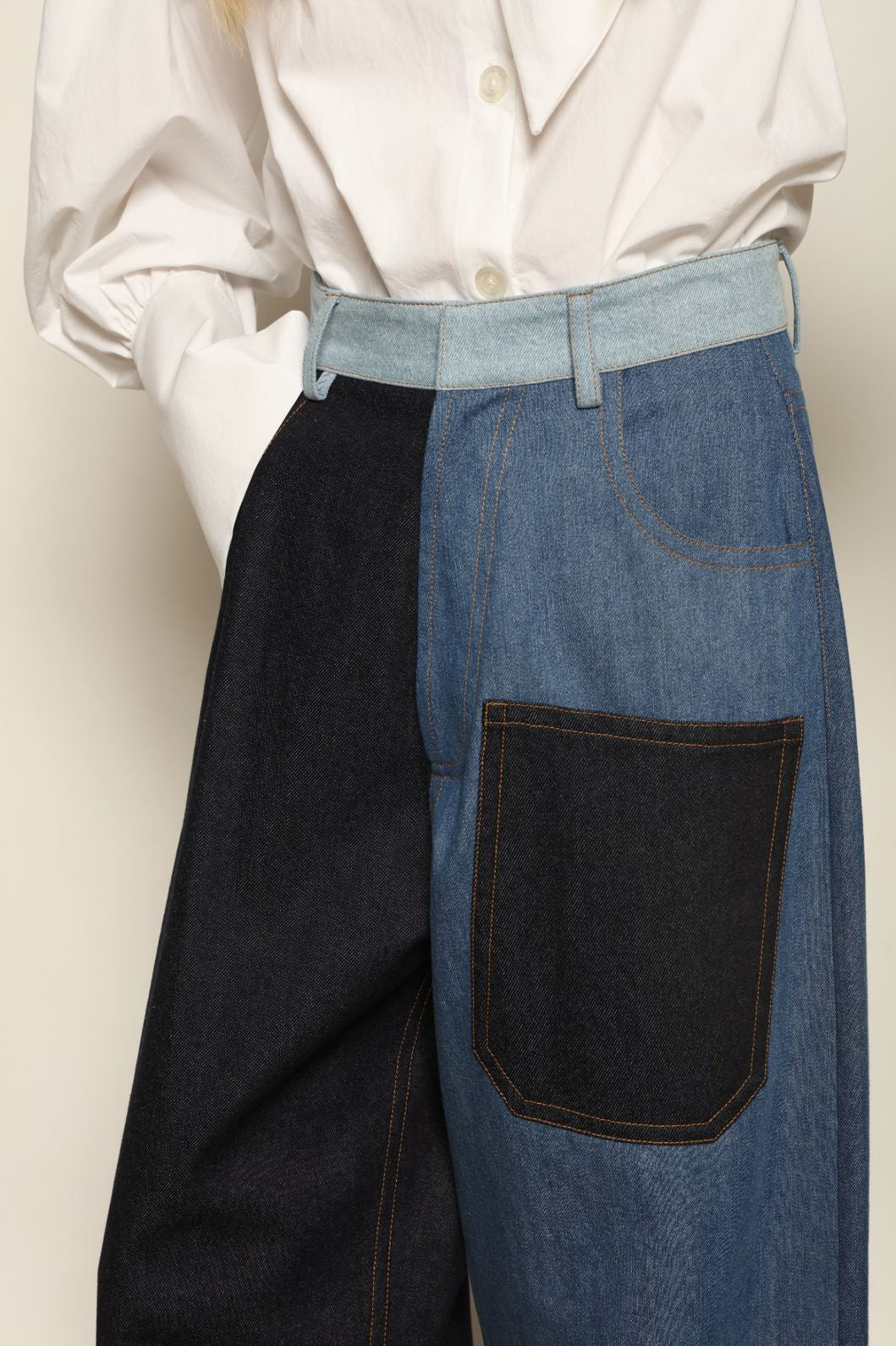 Model is wearing the Carla Denim Patchwork Pant by Maison Jejia, tailored denim trousers crafted from mixed-wash patches with a relaxed structured silhouette and fine stitching, curated in the House of Nomad Stories selection
