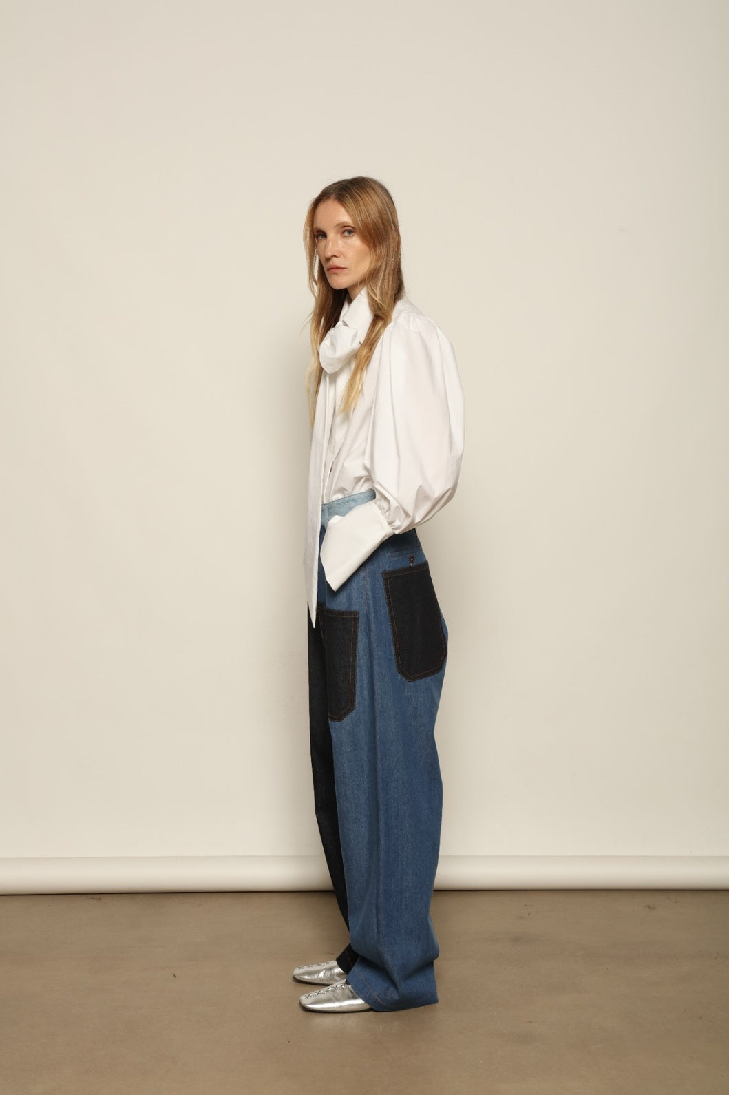 Model is wearing the Carla Denim Patchwork Pant by Maison Jejia, tailored denim trousers crafted from mixed-wash patches with a relaxed structured silhouette and fine stitching, curated in the House of Nomad Stories selection