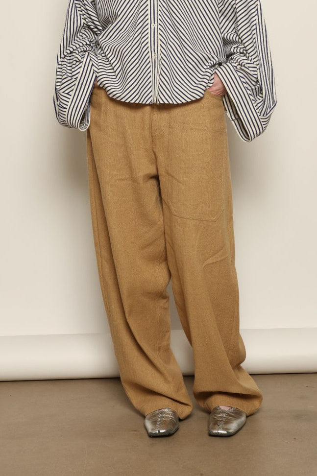 Model is wearing the Maison Jejia Carla Royal Yellow Cotton Pant, handcrafted in Italy with a relaxed silhouette and tailored waistband, from the House of Nomad Stories selection.
