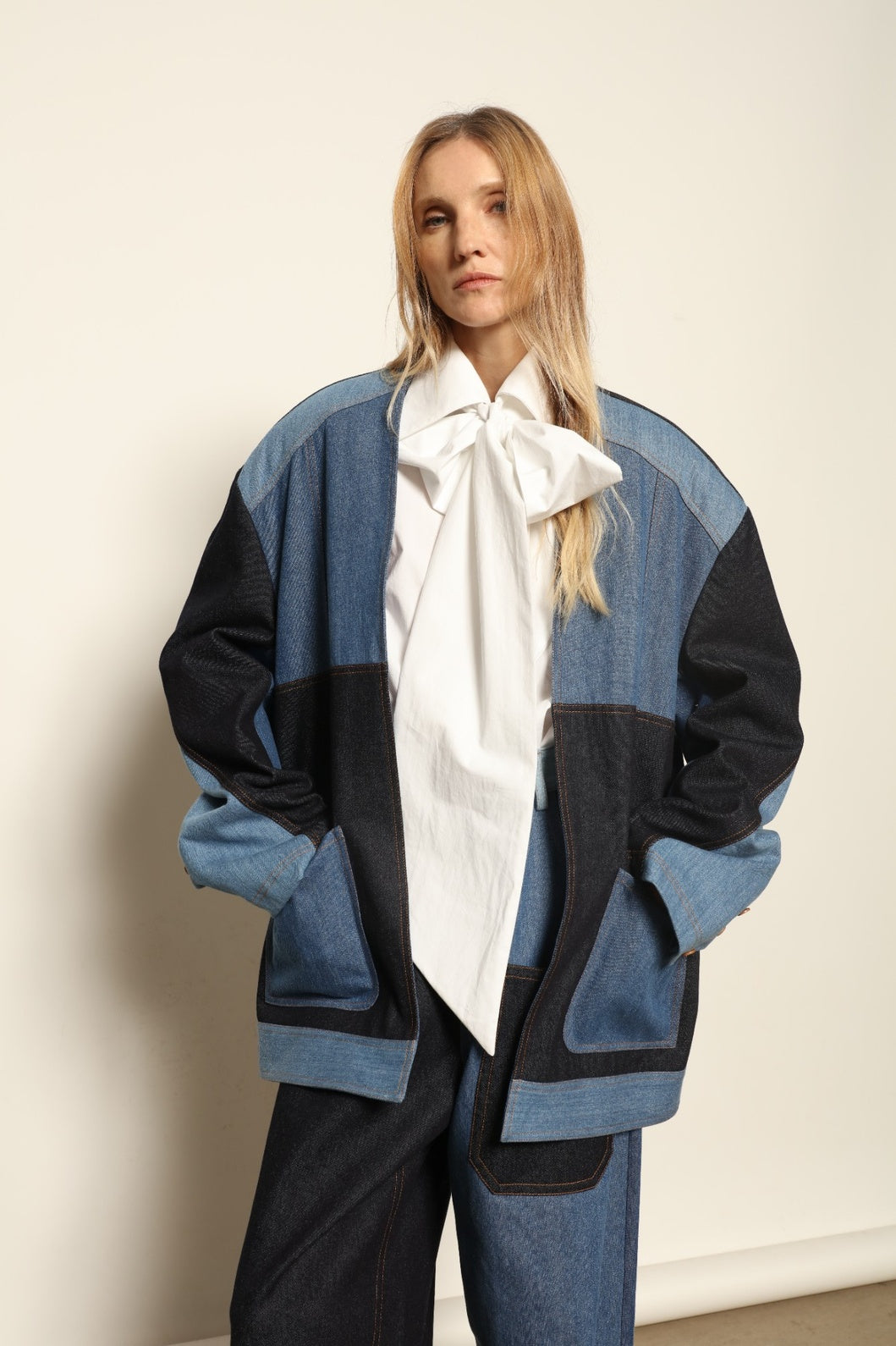 Model is wearing the Jonathan Denim Patchwork Blazer by Maison Jejia, an artisanal tailored blazer made from mixed-wash denim panels with sculpted shoulders and a relaxed sharp silhouette, curated in the House of Nomad Stories selection