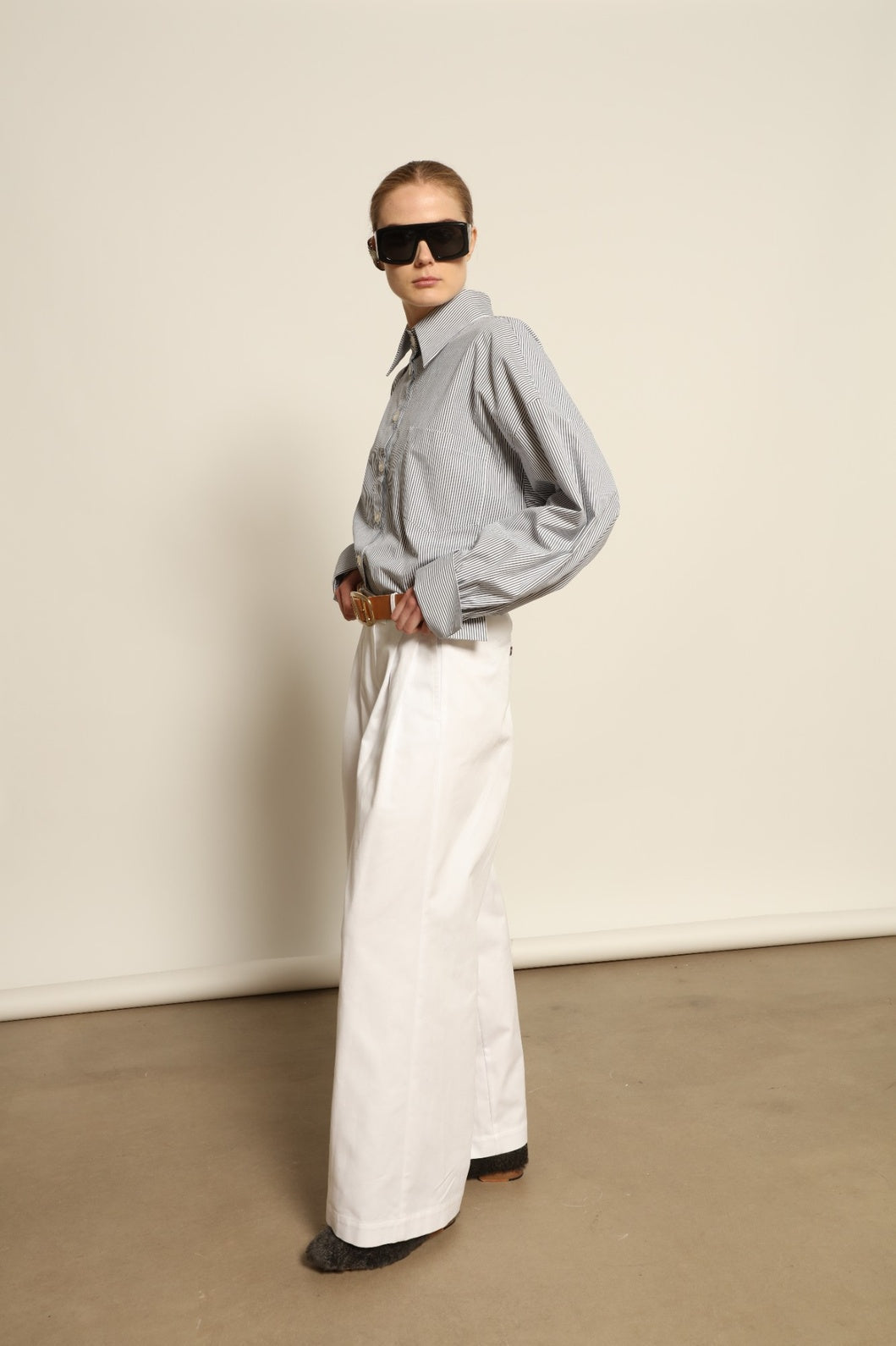Model is wearing the Katherine White A-Line Pant by Maison Jejia, structured cotton trousers with an elongating A-line silhouette, curated in the House of Nomad Stories selection.